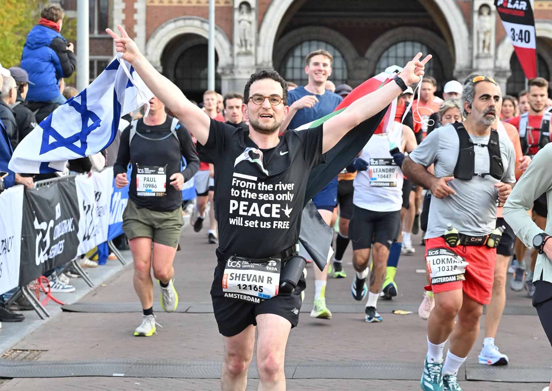 Shevan Marathon Amsterdam 1920 Vrouw die tijdens marathon in Amsterdam met Israëlische vlag en vredesboodschap triomfeert.